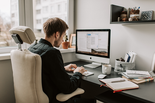 a person sitting at a desk in front of a computer